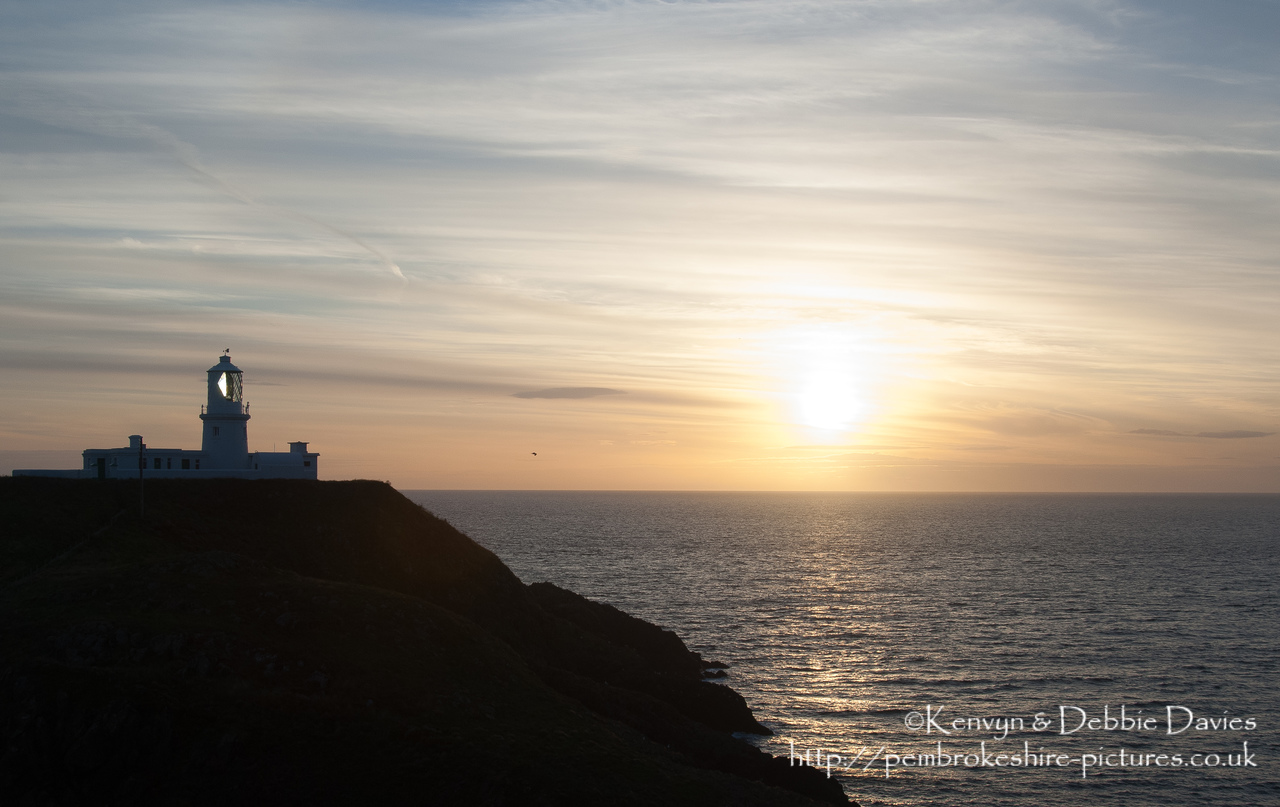 Strumble Head Lighthouse is built on Ynysmeicl (St. Michael's Island), an islet to the west of Fishguard, separated from the mainland by a very narrow gap.<br/><br/>The station was built in 1908 by Trinity House for the greater safety of sea traffic between Ireland and Fishguard Harbour which is located behind cliffs and a breakwater three miles to the east. The new light also formed a link with the existing South Bishop light, 18 miles to the south-west. This stretch of coast is very dangerous, and some 60 vessels are known to have been lost along it in the 19th Century alone.