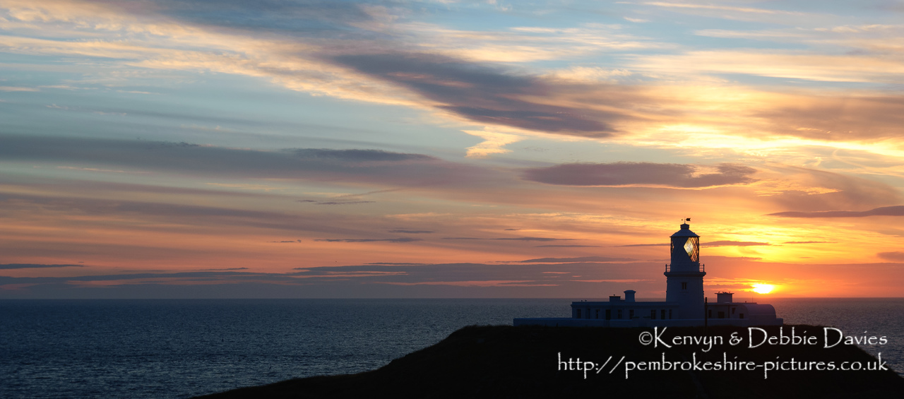 Strumble Head Lighthouse is built on Ynysmeicl (St. Michael's Island), an islet to the west of Fishguard, separated from the mainland by a very narrow gap.<br/><br/>The station was built in 1908 by Trinity House for the greater safety of sea traffic between Ireland and Fishguard Harbour which is located behind cliffs and a breakwater three miles to the east. The new light also formed a link with the existing South Bishop light, 18 miles to the south-west. This stretch of coast is very dangerous, and some 60 vessels are known to have been lost along it in the 19th Century alone.